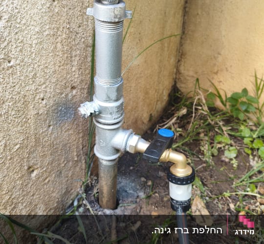 ברז מים מותקן על קיר עם צינור